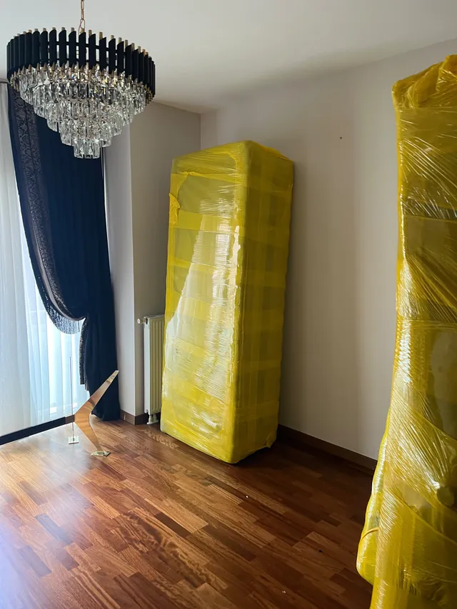 Sarı filmle tamamen kaplanarak taşımaya hazır hâle getirilen mobilyalar